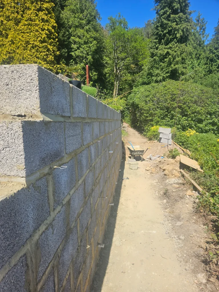 Newly constructed retaining wall with surrounding landscaping works in progress.