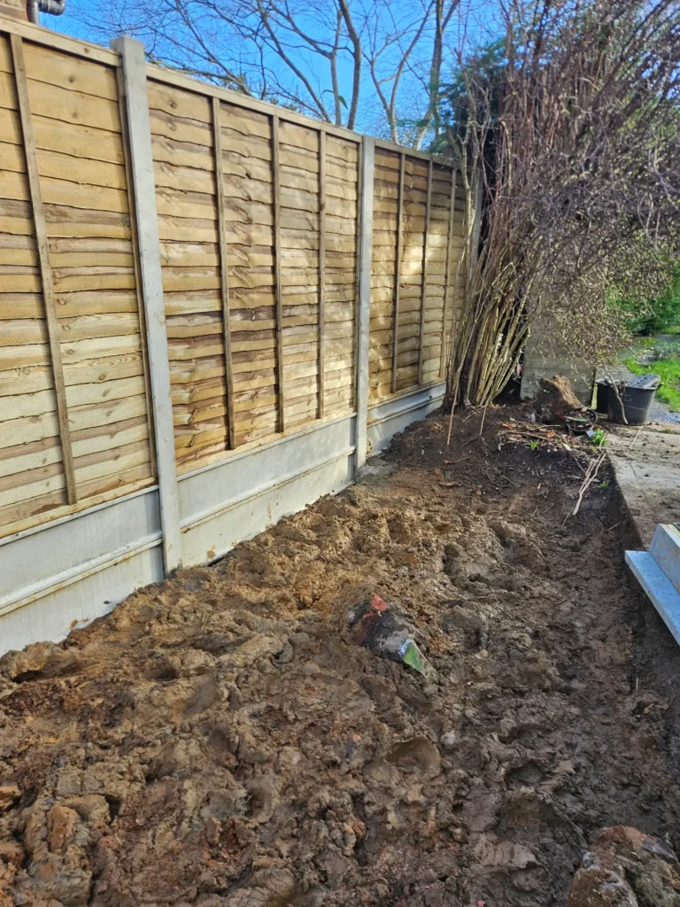 Newly installed timber panel fence along a garden boundary.