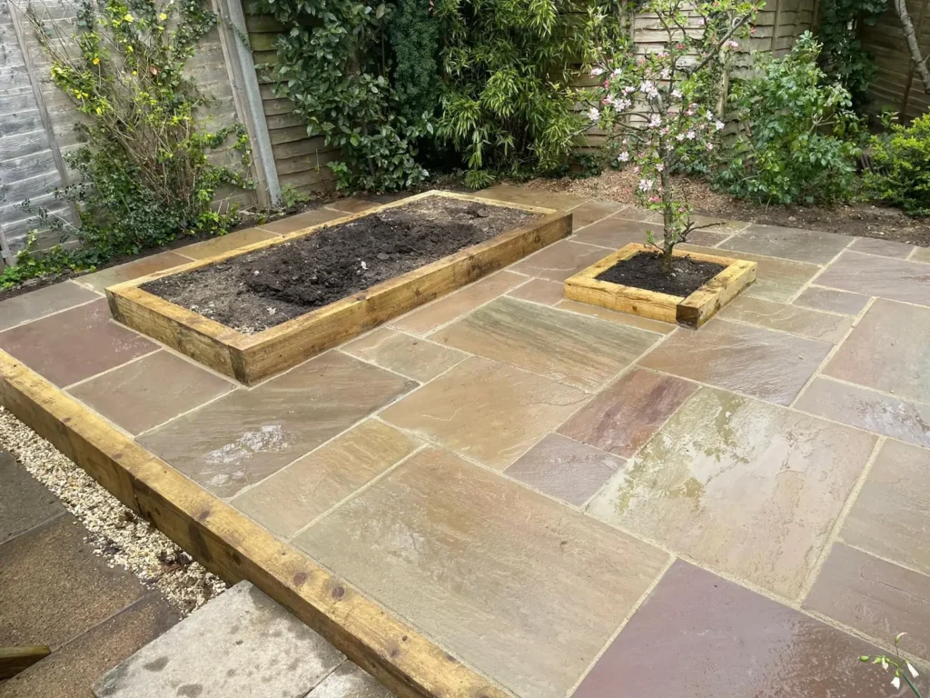Patio landscaping with raised planting beds and clean stone paving detail.